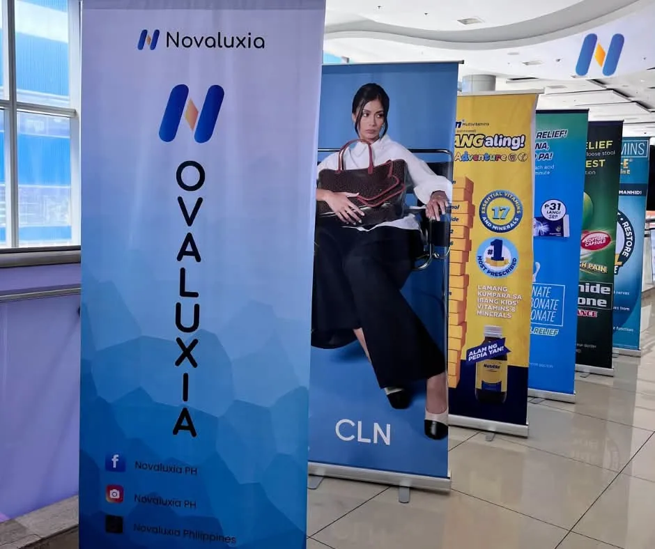 The Novaluxia roll-up banner standing in a row of exhibitor banners at the expo