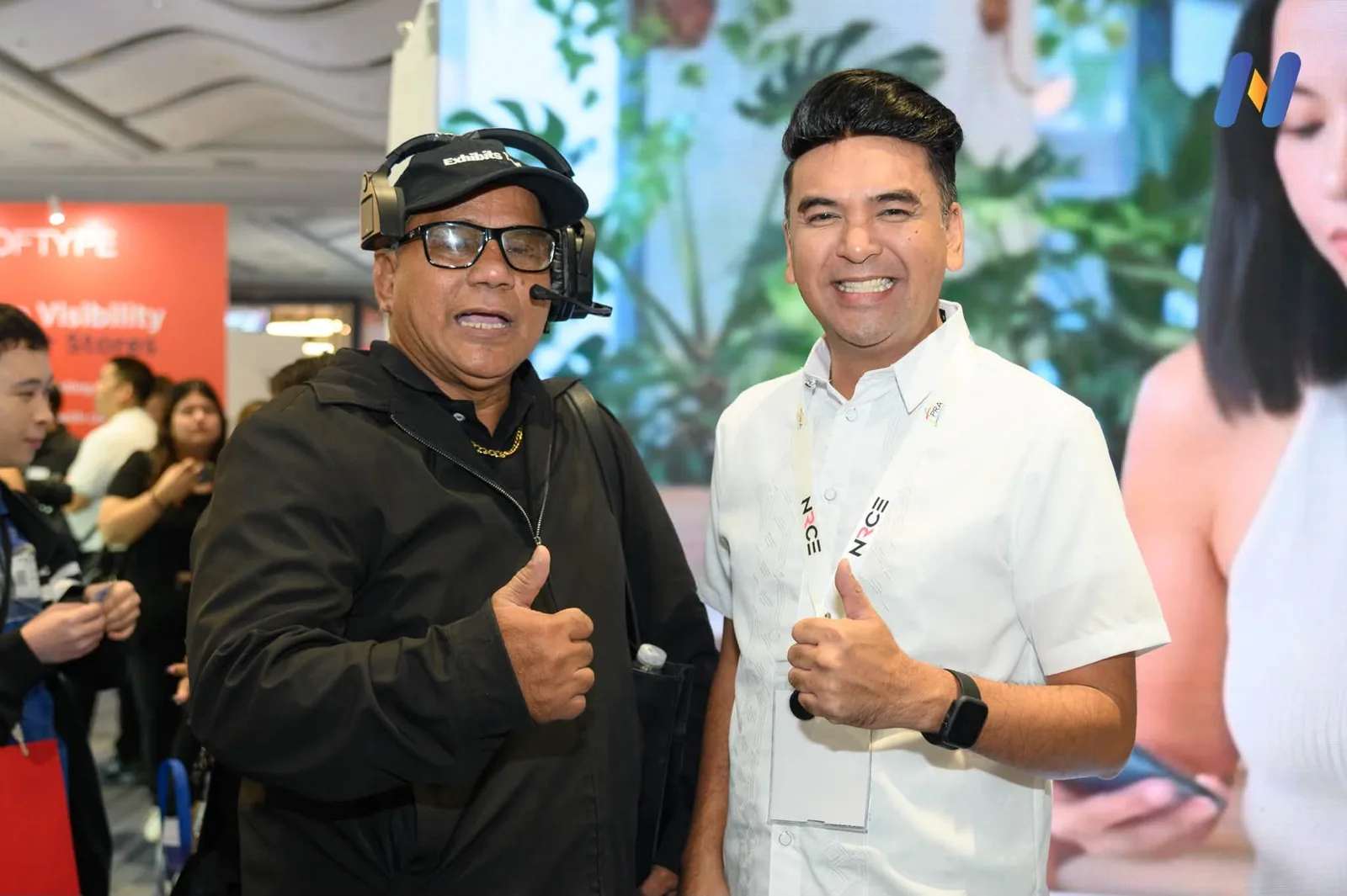 Two Novaluxia PH team members giving a thumbs up in front of the ASEAN FinTech Summit Manila 2026 backdrop